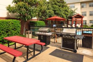 阿林顿阿灵顿原住客栈酒店的一个带烧烤架、野餐桌和烧烤设施的庭院。