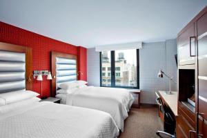 纽约The Chelsean New York的酒店客房设有两张床和红色的墙壁。