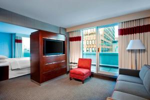 纽约The Chelsean New York的酒店客房配有床、沙发和电视。
