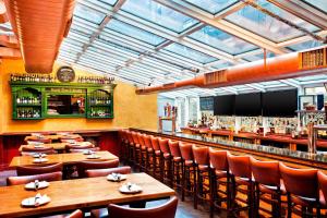 纽约The Chelsean New York的一间带木桌椅的餐厅和一间酒吧