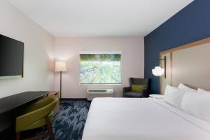 利索尼亚亚特兰大斯通克雷斯特万豪费尔菲尔德套房酒店的酒店客房设有一张大床和一张书桌。