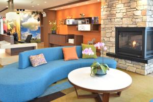 欧克莱尔欧克雷尔/奇珀瓦福尔斯费尔菲尔德客栈及套房的客厅设有蓝色沙发,配有壁炉