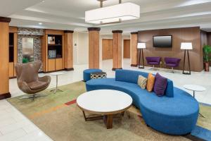杰克逊维尔杰克逊维尔巴特勒大道酒店及套房的大堂设有蓝色的沙发和电视。