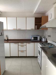 康考迪亚Amplio, luminoso y centrico dep. 3 dorm的厨房配有白色橱柜和炉灶烤箱。