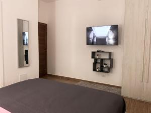 伊斯基亚R Home的一间卧室配有一张床,墙上配有电视