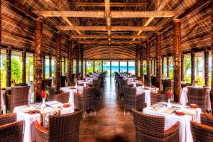 Mulifanua萨摩亚海滩喜来登度假村的一间设有白色桌椅的海洋餐厅