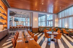 波士顿水岸万丽酒店的餐厅设有木桌、椅子和窗户。