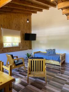 圣马丁德洛斯Cabaña Bigua的卧室配有一张床和一张桌子及椅子