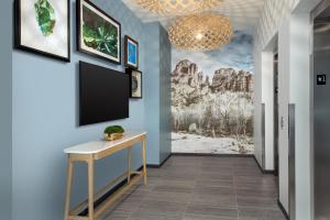 塞多纳Element Sedona的蓝色墙壁上的走廊上设有平面电视