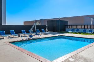 俄克拉何马城俄克拉荷马城喜来登中心酒店 的一座带椅子的建筑的顶部游泳池