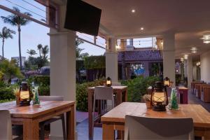 棕榈滩万豪阿鲁巴冲浪俱乐部度假酒店的餐厅设有木桌和平面电视。
