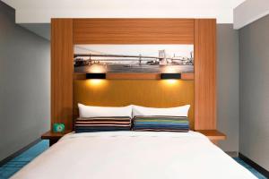 布鲁克林布鲁克林雅乐轩酒店的一间卧室配有一张大床和木制床头板