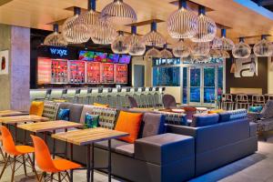 迈阿密迈阿密机场雅乐轩酒店的餐厅设有桌椅和吊灯。