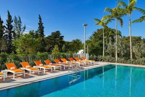 迈阿密迈阿密机场雅乐轩酒店的一排橙色躺椅和一个游泳池