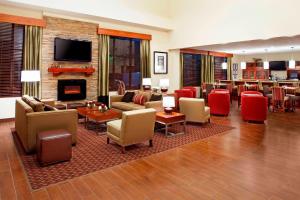 休斯顿休斯敦荷比机场福朋喜来登酒店的带沙发和椅子的客厅以及壁炉