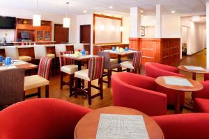 休斯顿休斯敦荷比机场福朋喜来登酒店的一间设有红色椅子和桌子的餐厅