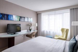 慕尼黑慕尼黑城市中心万豪酒店的酒店客房配有一张床和一张书桌及一台电视
