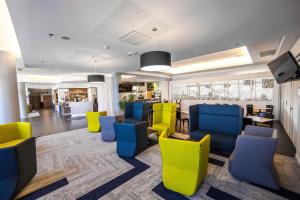 图卢兹万豪图卢兹机场度假酒店的一间设有黄色和蓝色椅子的等候室