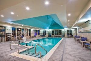 汉密尔顿汉密尔顿麦瑞特酒店的酒店大堂的游泳池,配有桌椅