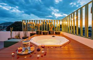 瓦哈卡市HOLT - Villa Noria - La Casa del Barro Verde的阳台上的热水浴缸,配有酒杯