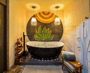 瓦哈卡市HOLT - Villa Noria - La Casa del Barro Verde的浴室设有浴缸,墙上挂着一幅大画