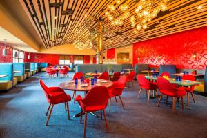 席勒公园芝加哥奥黑尔福朋喜来登酒店的一间餐厅,房间内设有红色的椅子和桌子