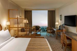 科威特Sheraton Kuwait, a Luxury Collection Hotel, Kuwait City的酒店客房配有一张床和一张书桌,而客房则配有一张书桌。