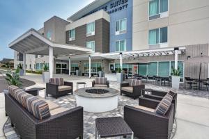 布雷登顿TownePlace Suites by Marriott Sarasota/Bradenton West的酒店庭院的椅子和火坑位于大楼前