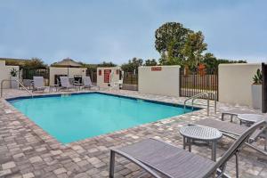 布雷登顿TownePlace Suites by Marriott Sarasota/Bradenton West的一个带椅子和围栏的大型游泳池