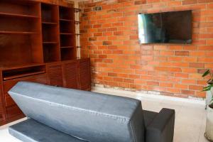 Villa Santho的客厅配有沙发和砖墙电视