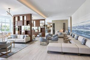 劳德代尔堡AC Hotel by Marriott Fort Lauderdale Beach的带沙发和椅子的客厅以及海洋