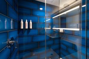 芝加哥Le Meridien Essex Chicago的蓝色瓷砖浴室设有玻璃淋浴间