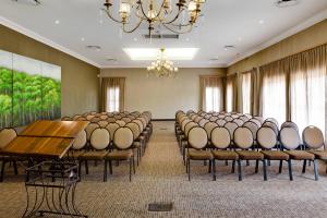 布隆方丹布隆方丹柳树湖万豪Protea酒店的一间会议室,配有椅子、桌子和吊灯