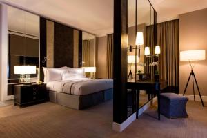 吉隆坡The Ritz-Carlton, Kuala Lumpur的一间卧室配有一张床、一张书桌和一面镜子