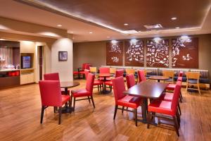 迪金森TownePlace Suites by Marriott Dickinson的用餐室配有桌子和红色椅子