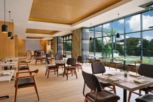 名古屋Four Points by Sheraton Batam的餐厅设有桌椅和大窗户。