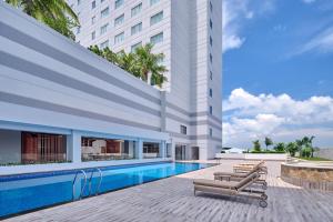 名古屋Four Points by Sheraton Batam的一座酒店,在一座建筑旁边设有游泳池