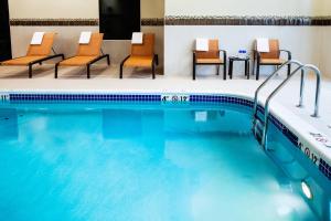 瓦拉瓦拉沃拉沃拉万怡酒店的一座带椅子和桌子的酒店游泳池