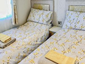 LeanachBallagan Lodge的一间卧室配有两张黄色鲜花的床。