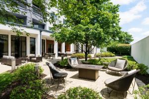North Wales费城蒙哥马利万怡酒店的一个带椅子和桌子的庭院和一棵树
