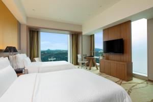 仙台The Westin Sendai的酒店客房设有两张床和一台平面电视。