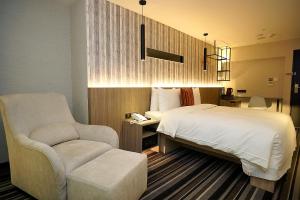 台北丰居旅店-忠孝馆的一间卧室配有一张床和一把椅子