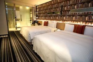 台北丰居旅店-忠孝馆的酒店客房带两张床和书墙