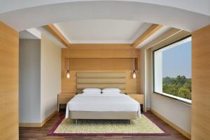 钦奈金奈万豪酒店的一间卧室设有一张床和一个大窗户