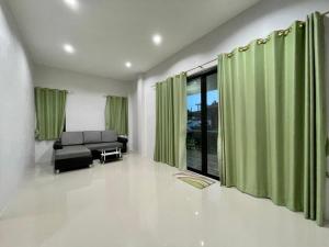 拉迈Shine of Hill Lamai Koh Samui的客厅配有绿色窗帘和沙发