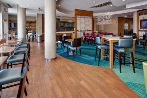 威奇托威奇托机场万豪春季山丘套房酒店的一个带桌椅的大堂和一间餐厅