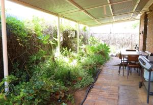 布罗肯希尔卡朋度假屋的庭院配有桌椅和植物
