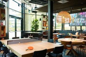 霍夫多普Moxy Amsterdam Schiphol Airport的餐厅配有乒乓球桌和椅子