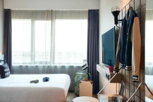 霍夫多普Moxy Amsterdam Schiphol Airport的一间卧室设有一张床和一个大窗户