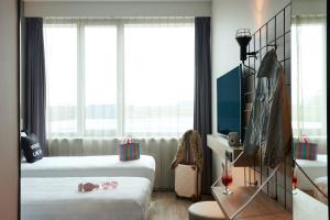 霍夫多普Moxy Amsterdam Schiphol Airport的酒店客房设有两张床和窗户。